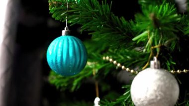 Evdeki bir Noel ağacının dalında dönen mavi bir Noel oyuncağı. Yaklaş. Yavaş hareket. Yüksek kaliteli FullHD görüntüler.