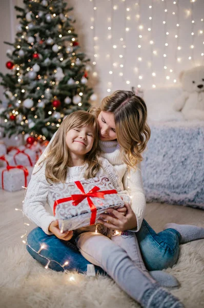 Aile Noel arifesi anne ve mutlu kız hediyeleri açıyor. Kızlar Noel 'i hediye kutuları ve Noel süsleri arasında karşılar..