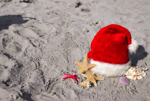 Χριστουγεννιάτικο Φόντο Άγιος Βασίλης Καπέλο Και Αστερίας Στην Αμμώδη Παραλία — Φωτογραφία Αρχείου