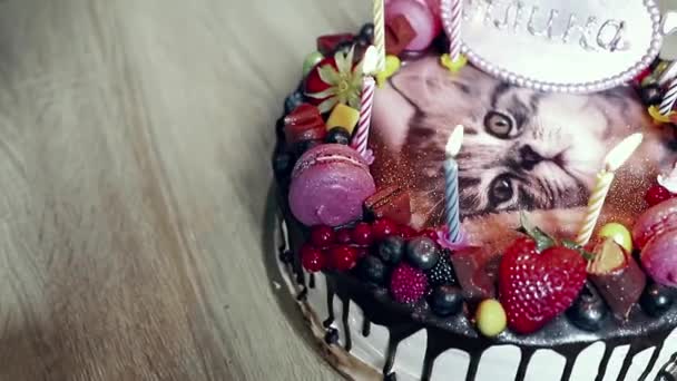 生日蛋糕 上面有一只小猫的照片 上面装饰着草莓 覆盆子 巧克力 旁边倒着黑巧克力 动作缓慢 — 图库视频影像