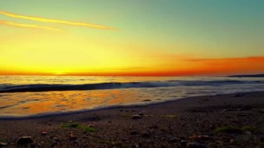 Jurmala sahilindeki görkemli günbatımı manzarası Letonya. Yanan gökyüzü ve parlayan altın dalgalar. Düşük hareket. Yüksek kaliteli FullHD görüntüler