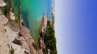 Yaz güneşli bir günde, İspanya 'nın La Pineda plajındaki güzel kaya oluşumları. Deniz bayırı. Salou. tatil köyü. Dikey video.