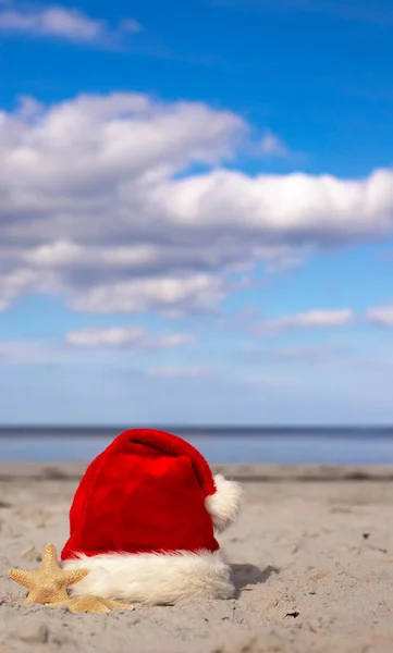 Świąteczne Tło Santa Claus Kapelusz Rozgwiazdy Piaszczystej Plaży Karta Świąteczna — Zdjęcie stockowe