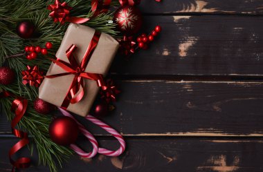 En üstteki fotoğrafta noel hediyesi kutusu, kırmızı noel ağacı oyuncakları, lolipoplar ve ahşap arka planda ladin brançı var. Metin için alanı olan Xmas arkaplanı. Kopyalama alanı.