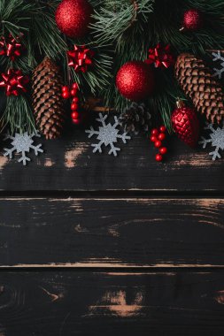 Noel arkaplanı kırmızı Noel ağacı oyuncakları, ahşap zemin üzerinde gümüş kar tanesi ve ladin dalları metin için yeri olan Xmas arkaplanı..