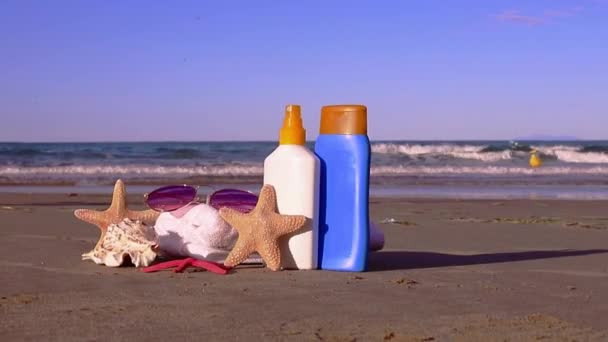 夏天的背景 防晒霜 防晒霜 海滩白陶井 贝壳和沙滩上的海星 暑假的概念 优质Fullhd影片 — 图库视频影像