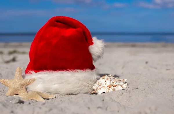 圣诞节的背景圣诞老人的帽子和海星在沙滩上 圣诞贺卡和日历的概念 圣诞假期的旅游票销售概念 复制空间 高质量的照片 — 图库照片