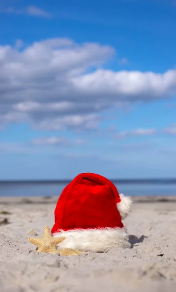 圣诞节的背景圣诞老人的帽子和海星在沙滩上 圣诞贺卡和日历的概念 圣诞假期的旅游票销售概念 复制空间 高质量的照片 — 图库照片