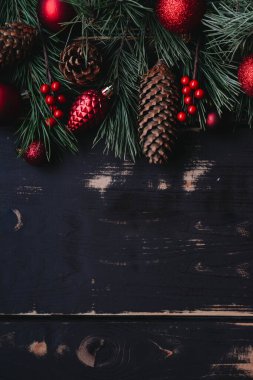Noel arkaplanı kırmızı Noel ağacı oyuncakları ve ağaç dalları ahşap zemin üzerinde Xmas arkaplanı ve metin için alan..