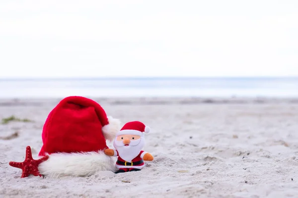 Świąteczne Tło Santa Claus Kapelusz Rozgwiazdy Santa Zabawki Piaszczystej Plaży — Zdjęcie stockowe