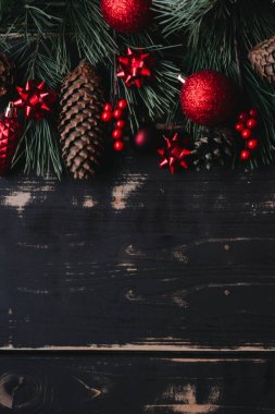 Noel arkaplanı kırmızı Noel ağacı oyuncakları ve ağaç dalları ahşap zemin üzerinde Xmas arkaplanı ve metin için alan..