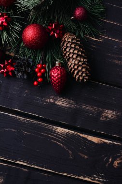 Noel arkaplanı kırmızı Noel ağacı oyuncakları ve ağaç dalları ahşap zemin üzerinde Xmas arkaplanı ve metin için alan..