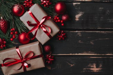 En üstteki fotoğrafta noel kutuları, kırmızı noel ağacı oyuncakları ve ahşap arka planda ladin dalları var. Metin için alanı olan Xmas arkaplanı. Kopyalama alanı.