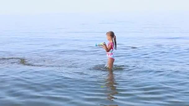 欧洲容貌的快乐女孩7岁在海里玩水枪 家庭暑假的概念 优质Fullhd影片 — 图库视频影像