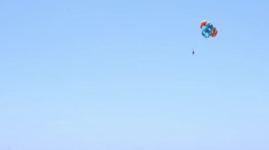 Mavi gökyüzünde paraşütle uçan bir adam. Yüksek kaliteli FullHD görüntüler