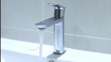 Musluktan su sorunsuz akıyor, lekesiz beyaz banyo günahını dolduruyor, kapanıyor. Yüksek kaliteli FullHD görüntüler