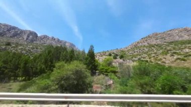 İspanya 'da çam ağaçlarıyla dolu bir kaya yığını otoyol boyunca manzara, arabanın penceresinden manzara. Yüksek kaliteli FullHD görüntüler