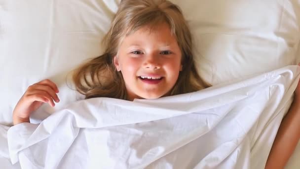 Egy Bájos Boldog Kislány Hosszú Hajjal Fekszik Egy Fehér Ágyon — Stock videók