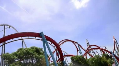 PORTAVENTURA DÜNYA, SALOU, İSPAN - 11 Haziran 2023: Açık gökyüzü altında yeşillikte süzülen heyecan verici lunapark treni yolculuğu. Yüksek kaliteli FullHD görüntüler