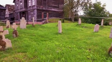 Eski yıpranmış mezar taşlarını ve fazla büyümüş çimenleri gösteren köy mezarlığı sahnesi. Yüksek kaliteli FullHD görüntüler