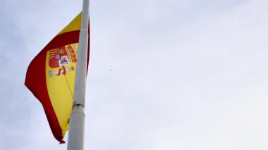 İspanya ulusal bayrağı açık bir gökyüzüne karşı bayrak direğinde dalgalanıyor. Yüksek kalite 4k görüntü