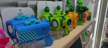 Benidorm, İspanya - 31 Mayıs 2025: AleHop shop. Çeşitli renkli oyuncak su tabancaları bir mağaza rafında düzenli olarak düzenlenir, neşeli tasarımlar ve parlak renkler mevcuttur, yaz etkinlikleri için mükemmeldir