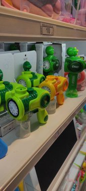 Benidorm, İspanya - 31 Mayıs 2025: AleHop shop. Oyuncak mağazasının rafına yerleştirilmiş renkli baloncuklu silahlar, eğlenceli tasarımlar sergiliyor ve çocukları açık hava aktivitelerinden zevk almaya davet ediyor.