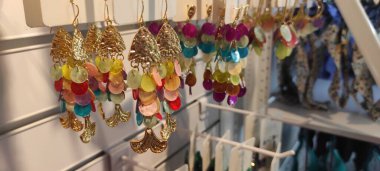 Benidorm, İspanya - 31 Mayıs 2025: AleHop shop. Canlı balık şekilli küpeler, renkli boncuklar ve karmaşık tasarımlarla sergilenen bir rafta asılı, moda aşıkları ve mücevher koleksiyoncuları için mükemmel.