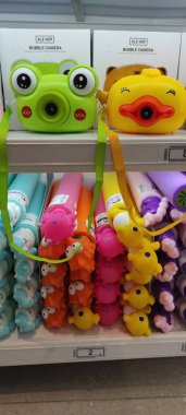 Benidorm, İspanya - 31 Mayıs 2025: AleHop shop. Kurbağa ve ördek şeklinde oyuncu baloncuk kameralar renkli aksesuarlarla çevrili bir mağaza rafında sergileniyor ve eğlenceli bir alışveriş ortamı yaratıyor.