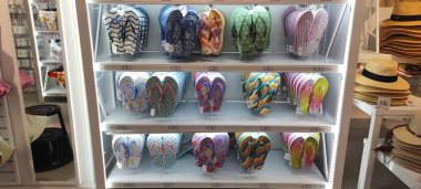 Benidorm, İspanya - 31 Mayıs 2025: AleHop shop. Bir perakende mağazasında raflara dizilmiş canlı parmak arası terlikler, çeşitli renkleri ve desenleri vurguluyor, yaz ayakkabıları ve plaj tarzı için mükemmel.