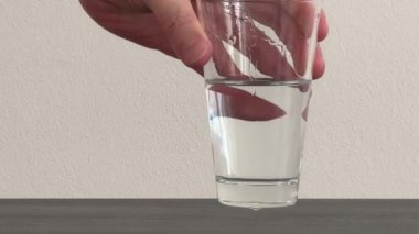 Bir adamın eli içtikten sonra bir bardak su koyar. Bir bardak su getirdim. Yüksek kalite 4k görüntü