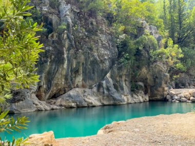 Dağ kanyonunda kayaların yanında akan mavi gök mavisi suyu olan güzel bir dağ nehri. Yüksek kalite fotoğraf