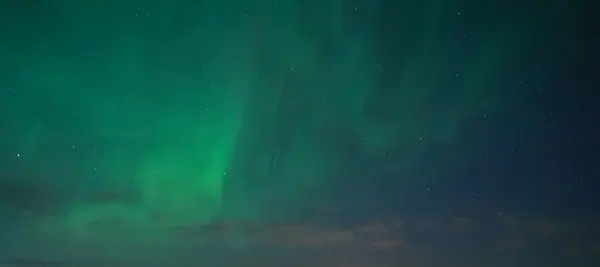 Karanlık ufukta sersemletici yeşil aurora borealis parlak kuzey ışıkları yıldızlı gece gökyüzünde dans ederek büyüleyici bir doğal fenomen yaratıyor. Seyahat için ideal, doğa..