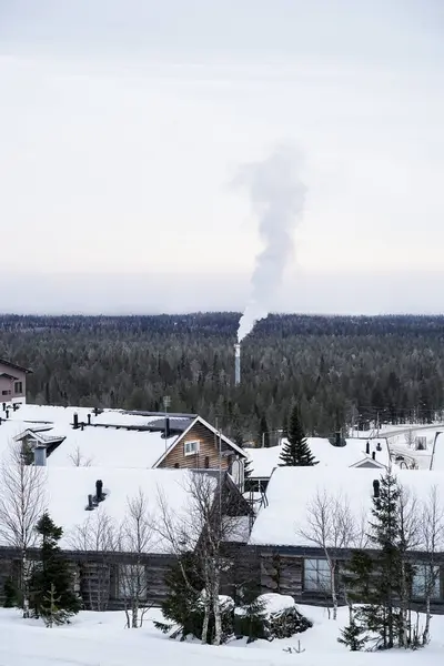 Kar Köyü 'nde Kış Dumanı Yükseliyor. Soğuk gökyüzüne karışan, uzak bir bacadan yükselen dumanla huzurlu bir kış köyü..