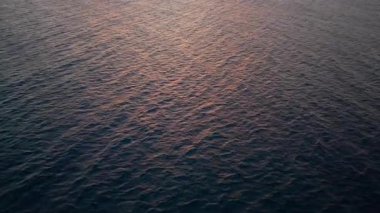 Okyanustan hafif dalgalanmalarla altın gün doğumu gökyüzüne, açık havaya, doğal ışıkta parlayan sakin deniz manzarasına. Kraliyetin yüksek kalitede ücretsiz en iyi güneş doğar.