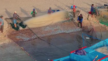 Balıkçıların sahilde ağ taşıması, otantik kültür, kırsal yaşam tarzı, Ninh Thuan, Vietnam 'da deniz mahsulleri ve deniz ürünleri geleneği. Balıkçı tekneleri ve ağlar kıyıda, yerel balıkçılar