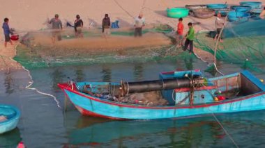 Balıkçıların sahilde ağ taşıması, otantik kültür, kırsal yaşam tarzı, Ninh Thuan, Vietnam 'da deniz mahsulleri ve deniz ürünleri geleneği. Balıkçı tekneleri ve ağlar kıyıda, yerel balıkçılar