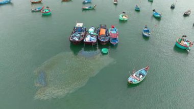 Tahta tekneler ve kıyı evleri olan balıkçı limanı, Vietnam 'daki otantik köy hayatı, dağlarla dolu deniz manzarası, kültür, seyahat ve turizm sahnesi, deniz yaşam tarzı ve kültürü. 