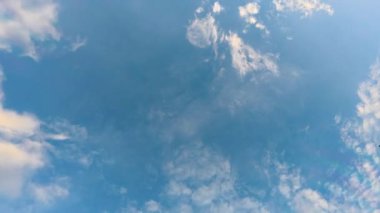 Güneşli bir günde açık mavi bir gökyüzünde süzülen tüylü bulutların hızlandırılması ya da zamanlaması. Parlak ve huzurlu hava manzarası, beyaz bulutlar canlı mavi bir gökyüzünde hızla hareket ediyor. 