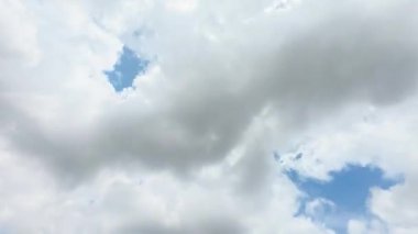 Güneşli bir günde açık mavi bir gökyüzünde süzülen tüylü bulutların hızlandırılması ya da zamanlaması. Parlak ve huzurlu hava manzarası, beyaz bulutlar canlı mavi bir gökyüzünde hızla hareket ediyor. 