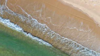 Drone view of beach and sea wave with foam, clean sand shoreline, natural seascape, tropical paradise, perfect for travel, holiday, tourism and nature concepts 