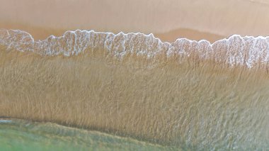 Drone view of beach and sea wave with foam, clean sand shoreline, natural seascape, tropical paradise, perfect for travel, holiday, tourism and nature concepts 