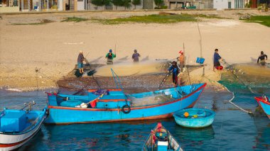 Balıkçıların sahilde ağ taşıması, otantik kültür, kırsal yaşam tarzı, Ninh Thuan, Vietnam 'da deniz mahsulleri ve deniz ürünleri geleneği. Balıkçı tekneleri ve ağlar kıyıda, yerel balıkçılar
