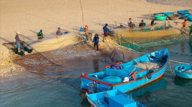 Balıkçıların sahilde ağ taşıması, otantik kültür, kırsal yaşam tarzı, Ninh Thuan, Vietnam 'da deniz mahsulleri ve deniz ürünleri geleneği. Balıkçı tekneleri ve ağlar kıyıda, yerel balıkçılar