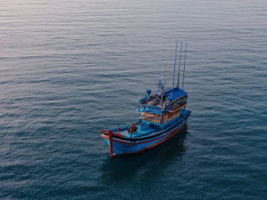 Vietnam açıklarında yüzen tahta balıkçı teknesi, balıkçıların yaşam tarzı, tropik deniz manzarası ve deniz mirası. Geleneksel gemi deniz kültürünü, geçim kaynağını sembolize ediyor 