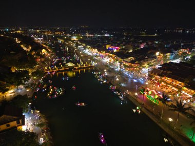 Panoramic aerial drone view of Hoi An Ancient town with boat tour and beautiful lanterns in evening. UNESCO world heritage. One of the most travel popular touristic destinations