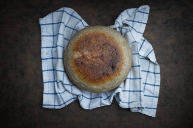 Koyu bir arka planda ev yapımı yuvarlak ekmek. Yukarıdan görüntüle.
