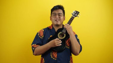 Ukulele tutan Asyalı genç adamın portresi