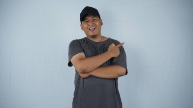 Asyalı Müslüman adam gülümsüyor ve beyaz arka planda kendi tarafını gösteriyor.