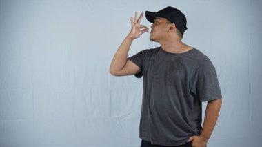 Siyah tişört giyen Asyalı bir gencin portresi ayakta duruyor ve el işareti yapıyor. beyaz arkaplanda izole.